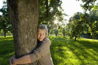 Mature_woman_embracing_tree__eyes_closed__tree_hugging__tree_huggers_810_500_75_s_c1.jpg